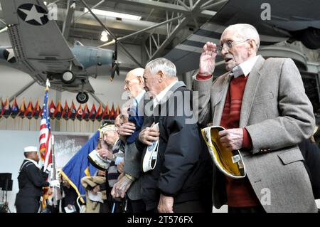 US Navy Pearl Harbor survivor Evans Brassett salutes and sings as the national anthem is played during a ceremony commemorating.jpg Stock Photo