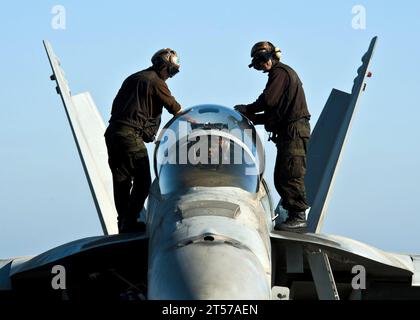 US Navy Sailors wipe down the canopy of a jet.jpg Stock Photo