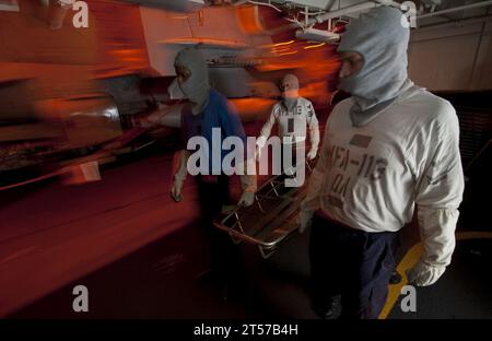 US Navy Stretcher bearers move in to evacuate casualties during a general quarters drill in the hangar bay aboard the Nimitz-cla.jpg Stock Photo