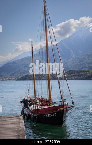 Old style sailing yacht prepares to dock alongside a jetty on Lake Como, Italy Stock Photo