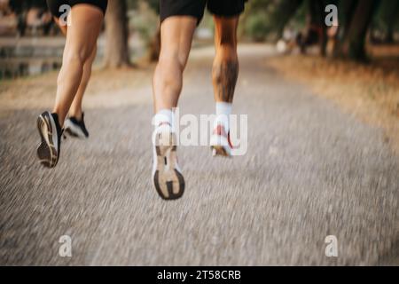 Two fit joggers running in a park during late evening training. Stock Photo