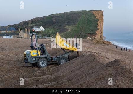 West Bay, Dorset, UK. , . Locals work into the late afternoon repairing the flood defences which were breached by Storm Ciaran at West Bay on the Dorset Coast Credit: Tom Corban/Alamy Live News Stock Photo
