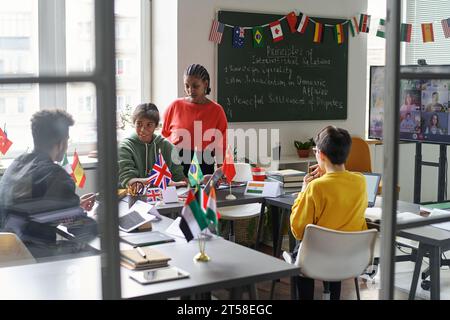 Group of students cooperating with teacher in the classroom at school Stock Photo