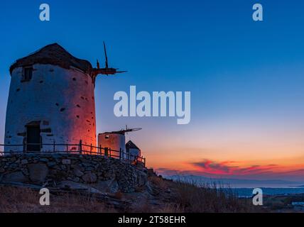 Traditional Cycladic windmills in Vivlos village at dusk, Naxos Stock Photo