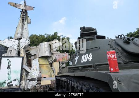 VIETNAM, Hanoi, Military Museum, military equipment and war scrap from french colonial war 1946-1954 and the US american war in Vietnam 1955 – 1975, US battle tank M-48 Patton and wreckage of Grumman F6F Hellcat an American carrier-based fighter aircraft used by the french colonial army, shot down at battle in Dien Bien Phu 1954 , famous photograph or image of vietnamese woman pulling a wing of shot down US aircraft, vietnamese Coca Cola can Stock Photo