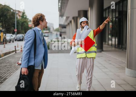 Architectural team discuss blueprint for sustainable building design in the city. Stock Photo