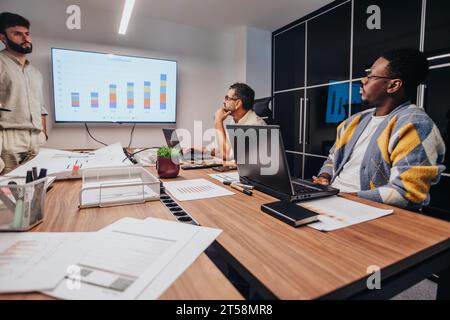 Multiracial Team of Architects and Engineers Collaborating in a Board Room for a Creative Project Stock Photo