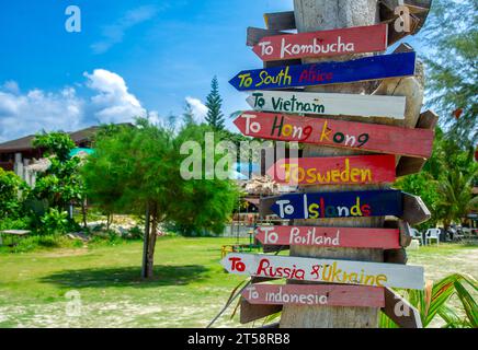Wooden arrow-shaped and coloured signposts showing directions to many places in the world. Stock Photo