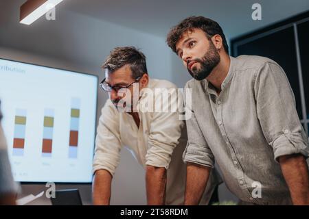 Business Professionals Collaborating on Architectural Plans in Corporate Board Room Stock Photo
