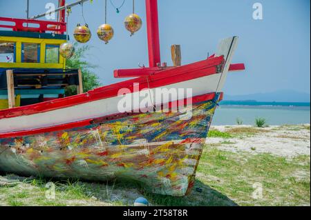 Abandoned fishing boats painted in many colors that are used ashore on the beach as restaurants for tourists Stock Photo