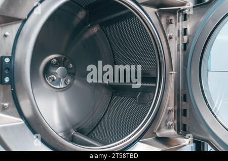 Shiny dryer close-up. High-quality photo of drying drum in dry cleaner. View from the inside. Stock Photo