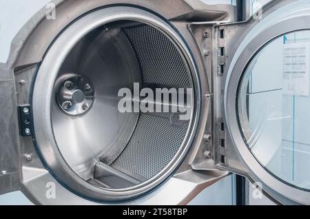 Close-up of an open shiny dryer. High-quality photo of drying drum in dry cleaner. View from inside Stock Photo