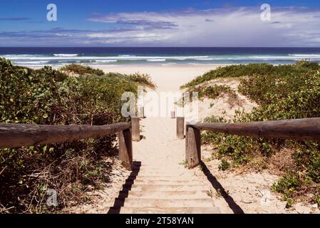 A sandy pathway leads down onto the beach at Wilderness in the Western Cape in South Africa Stock Photo