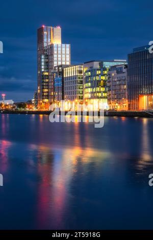 Modern offices and apartment buildings on Sir John Rogerson Quay, docklands, reflected in blurred Liffey River at dusk, blue hour, Dublin, Ireland Stock Photo