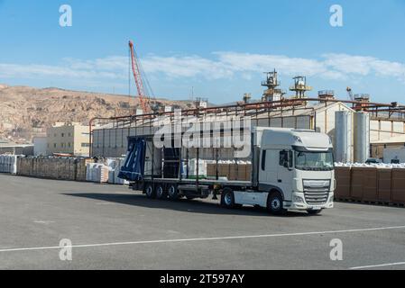 Truck with the side canvases open and empty waiting to be loaded with pallets with peat. Stock Photo