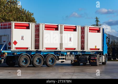 Truck with bottles connected to each other for the transport of hydrogen, H2, with a red label with a flame. Stock Photo