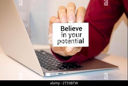 BELIEVE IN YOUR POTENTIAL text on white card, amid financial statements Stock Photo
