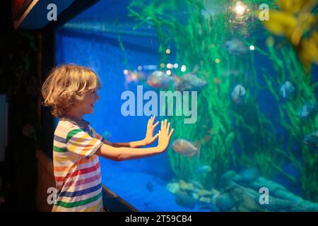 Family in aquarium. Kids watch tropical fish, marine life. Child ...