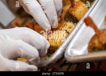 Decorating small potato appetizers to be set up for a catering event Stock Photo