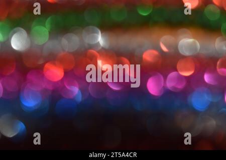 Light reflecting off of rows of brightly colored tinsel, making a bokeh, abstract design. Stock Photo