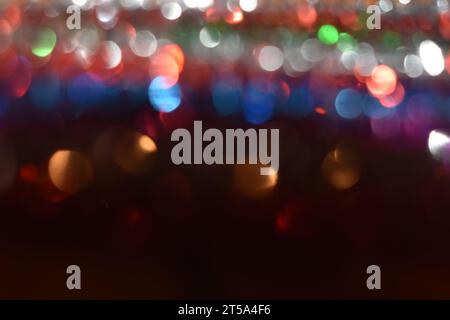 Light reflecting off of multi-colored tinsel, making an abstract design, bokeh. Black copy space at bottom Stock Photo