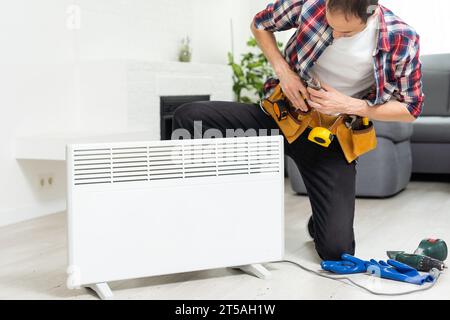 Handyman fix the radiator in the room Stock Photo