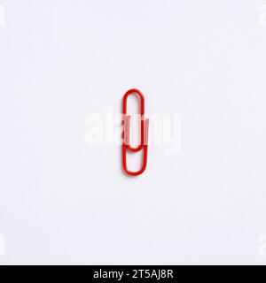 Red paper clip on white background with copy space. Stock Photo