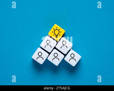 Teamwork and idea concept. Brainstorming and generating creative ideas. Employee and light bulb symbols on colorful cubes. Stock Photo