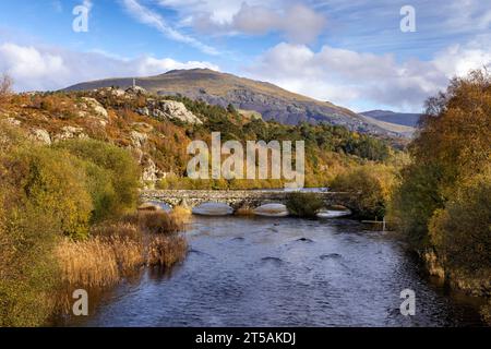 The old stone bridge over the river Rhythallt as it flows out of Llyn Padarn at Brynrefail near Llanberis in Snowdonia National park, North Wales Stock Photo