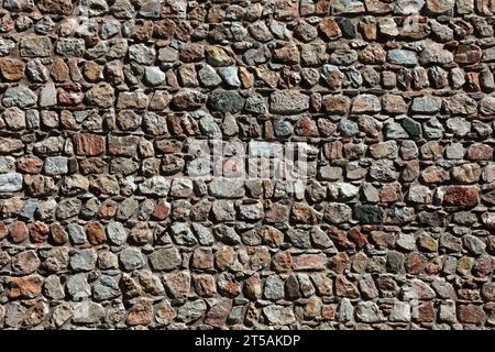 A wall made of rubble stones. Stone wall detail for backgrounds. Stock Photo