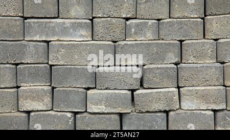 The surface of a wall or fence lined with gray bricks. Paving slabs of grey blocks of flat shape. Pavement blocks in city park. Park way materials Stock Photo