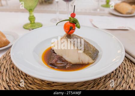 Confit of codfish loin topped with cherry tomato brochette. Closeup Stock Photo