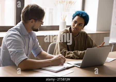 Two diverse business colleagues working at laptop together Stock Photo
