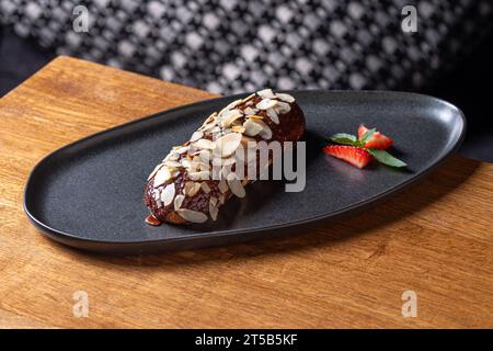 Salted Caramel Eclair plate. close-up on the table, serving in a restaurant, menu food concept. Stock Photo