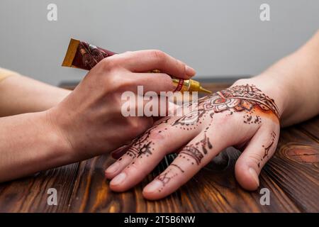 Artist making mehndi womans hand table Stock Photo