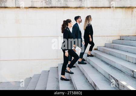 Side view business people walking upstairs Stock Photo