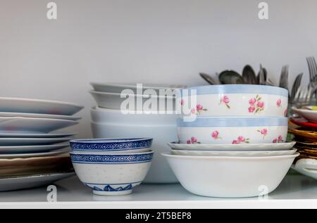 Tableware and dinnerware on a kitchen shelf. Stock Photo