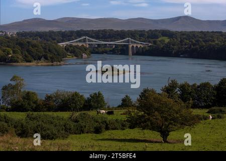 The iconic Menai Bridge, a suspension bridge designed by Thomas Telford and built in the 19th century. The bridge spans the Menai Strait, connecting m Stock Photo