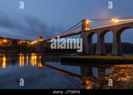 The iconic Menai Bridge, a suspension bridge designed by Thomas Telford and built in the 19th century. The bridge spans the Menai Strait, connecting m Stock Photo