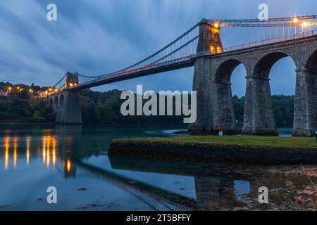 The iconic Menai Bridge, a suspension bridge designed by Thomas Telford and built in the 19th century. The bridge spans the Menai Strait, connecting m Stock Photo