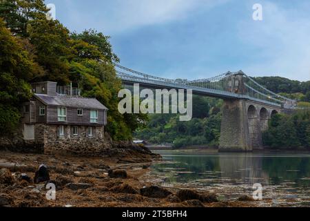 The iconic Menai Bridge, a suspension bridge designed by Thomas Telford and built in the 19th century. The bridge spans the Menai Strait, connecting m Stock Photo