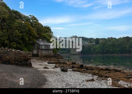 The iconic Menai Bridge, a suspension bridge designed by Thomas Telford and built in the 19th century. The bridge spans the Menai Strait, connecting m Stock Photo