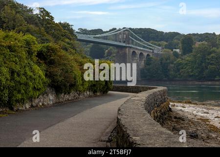 The iconic Menai Bridge, a suspension bridge designed by Thomas Telford and built in the 19th century. The bridge spans the Menai Strait, connecting m Stock Photo