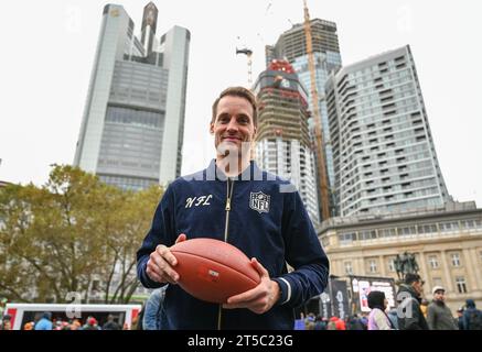 04 November 2023, Hesse, Frankfurt/Main: American Football: NFL, Before the season game Kansas City Chiefs - Miami Dolphins. Alexander Steinforth, General Manager of the NFL Germany, stands in front of the skyscrapers with a football during a press event at Fanfest. Photo: Arne Dedert/dpa Stock Photo