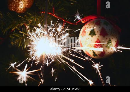 Sparkler burning on a Christmas tree.Christmas tree decoration and sparkler close-up Stock Photo