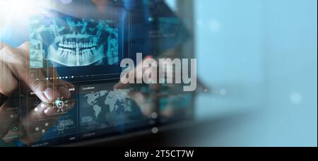 Dentist looking on the virtual Ai x-ray of a jaw working with a computer in the dental office. Stock Photo