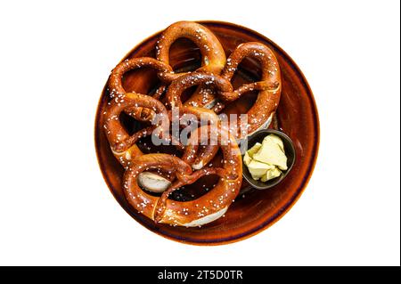 Freshly baked homemade pretzel with salt on a rustic plate. Isolated on white background Stock Photo