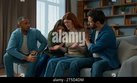 Upset woman cry desperate bullying at home multiethnic team friends support sad anxious girl on group psychological therapy colleagues women and men Stock Photo