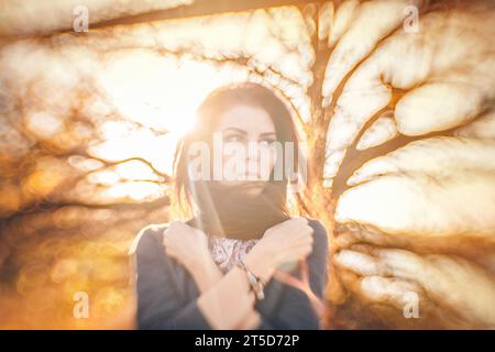 In this mesmerizing portrait, a brunette woman takes center stage amidst the enchanting colors of autumn. The unique and powerful background blur, ach Stock Photo