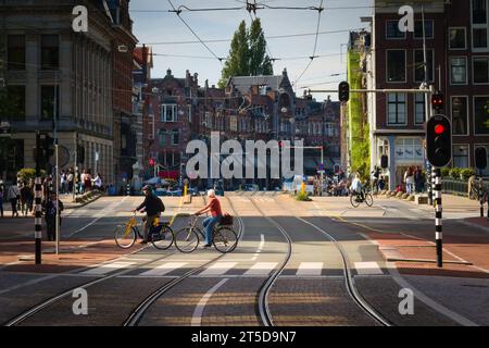 Senior couple riding bicycles across the street in Amsterdam, Netherlands. Stock Photo